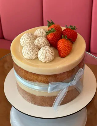 Bolo com brigadeiros brancos e morangos